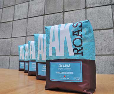 Four blue Solstice whole-bean coffee bags