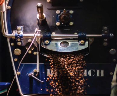 Industrial coffee roaster dumping roasted beans
